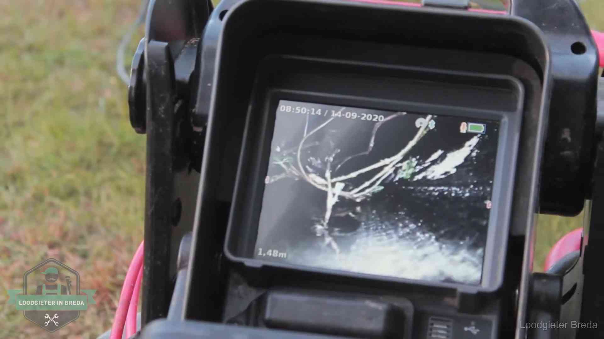 Monitor van een rioolcamera toont wortelingroei in de rioolbuis bij een woning in Breda