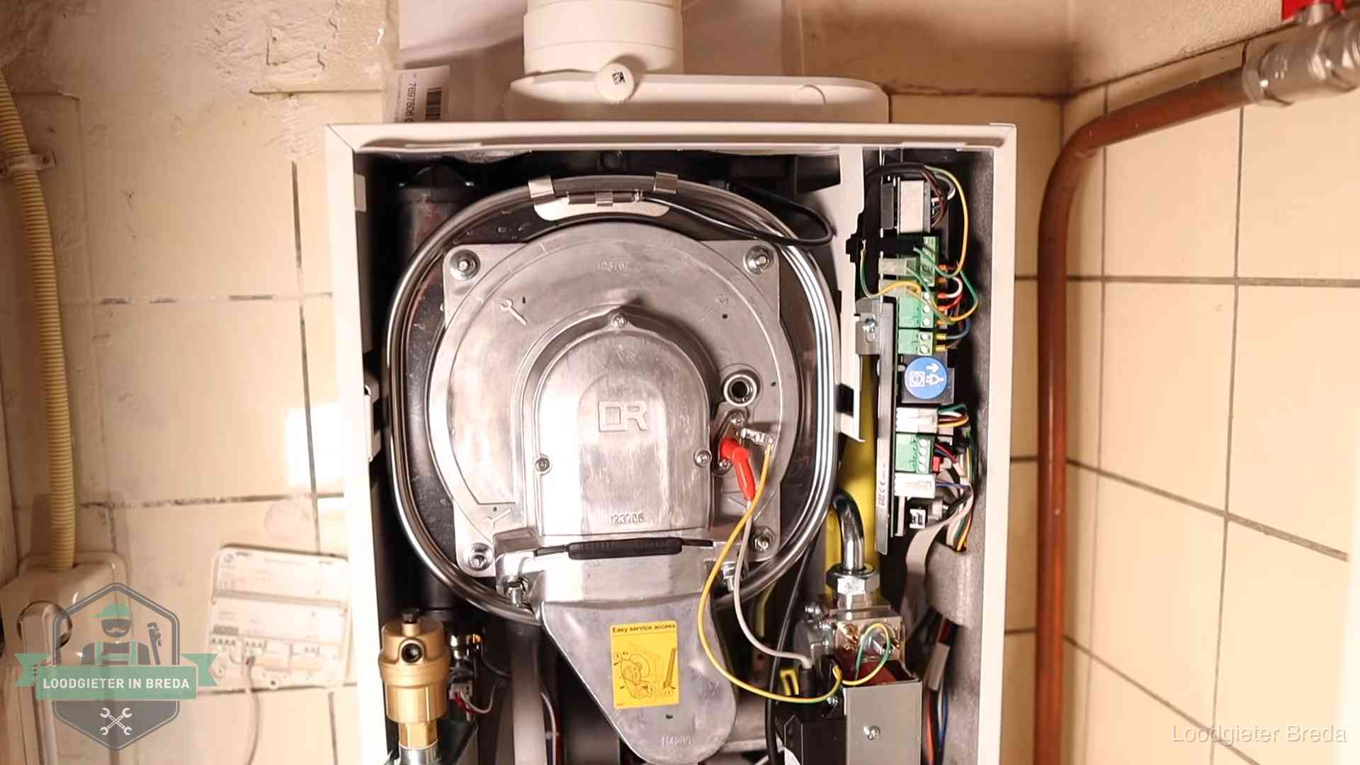 Geopende cv-ketel met warmtewisselaar tijdens periodiek onderhoud in Breda