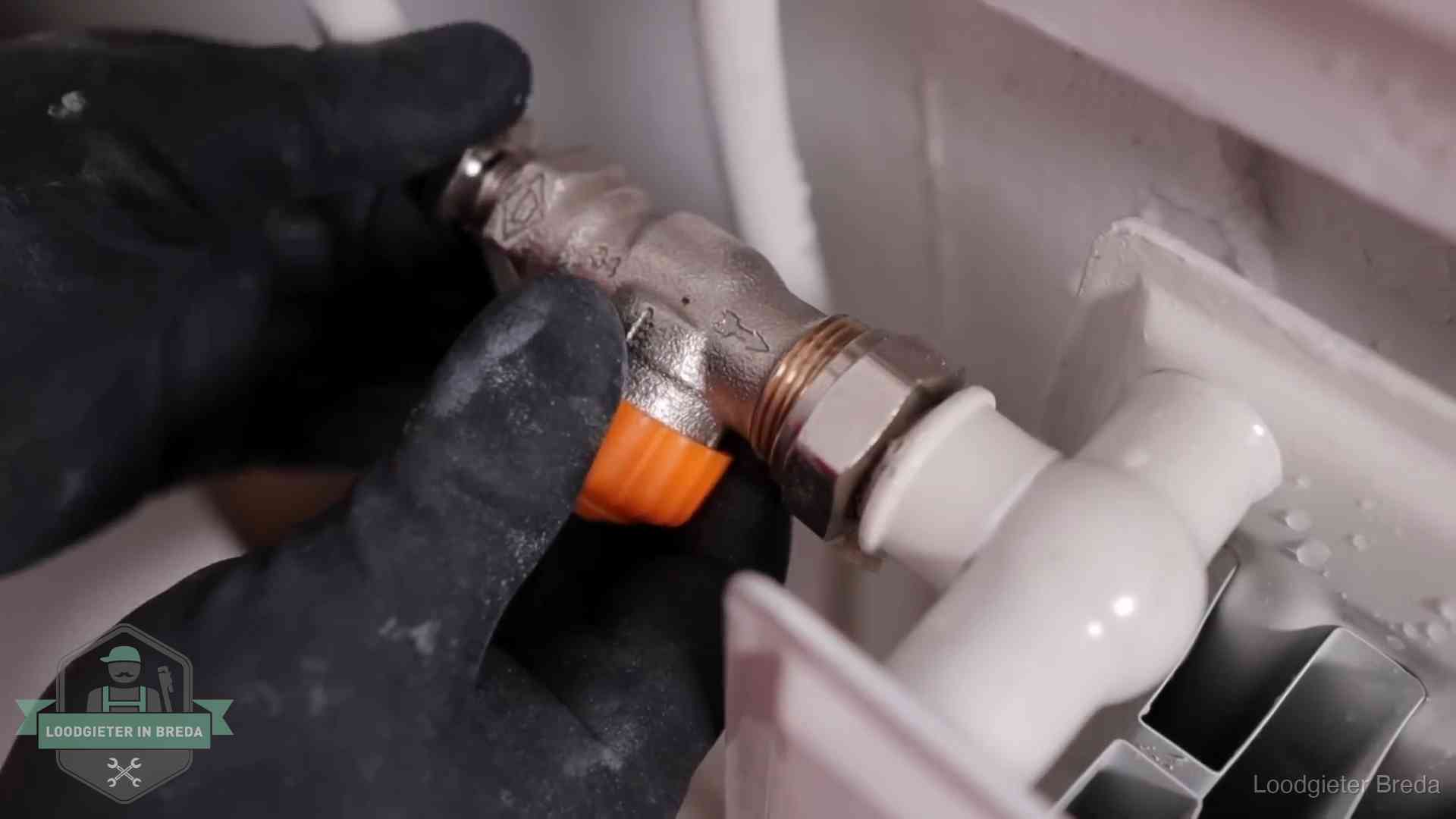 Thermostaatkraan wordt gemonteerd op een radiator in Breda voor het stookseizoen