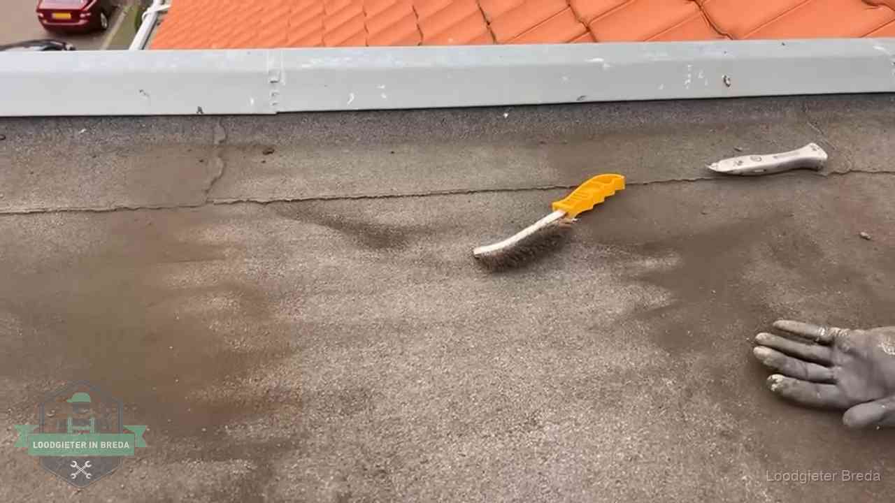Kosten van daklekkage-reparatie in Breda Dakdekker bereidt een bitumen plat dak voor op reparatie bij de daktrim in Breda