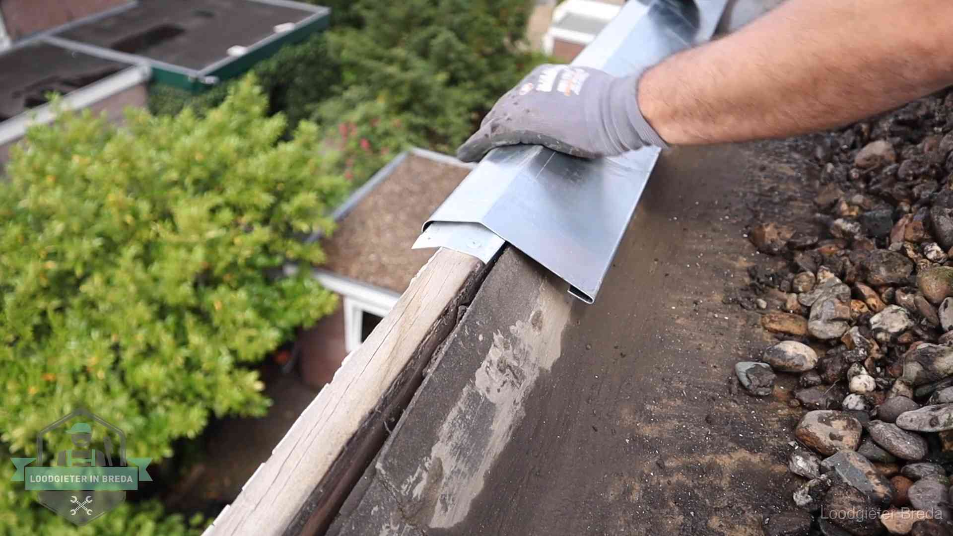 Daklekkage per wijk in Breda Dakdekker plaatst een zinken deklijst op een dakrand met uitzicht over een woonwijk in Breda