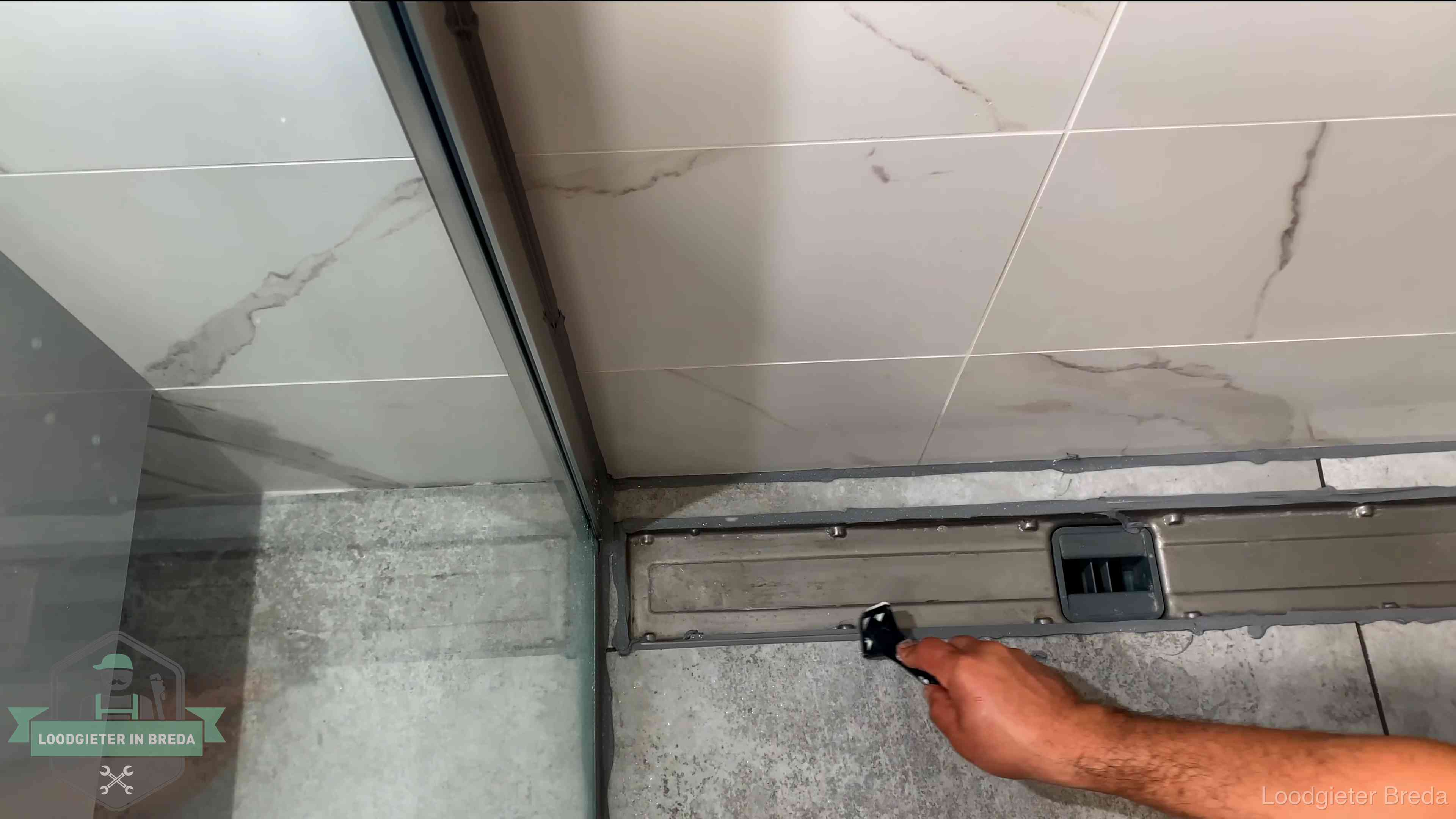 Lekkage in de badkamer verhelpen in Breda Verse kitrand langs de douchegoot in een betegelde badkamer in Breda