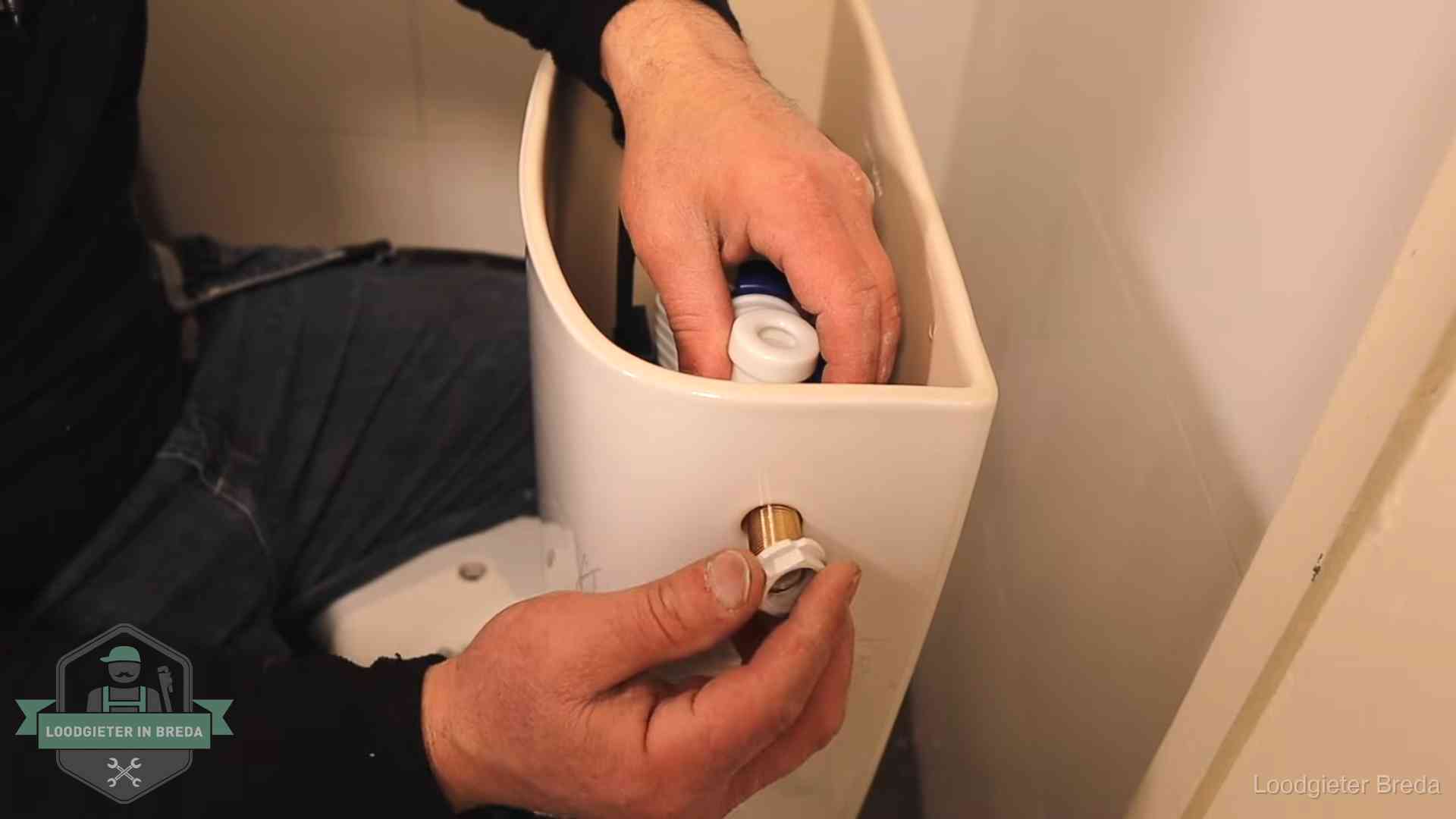 Loodgieter monteert de vlotterkraan van een stortbak bij een toilet in Breda