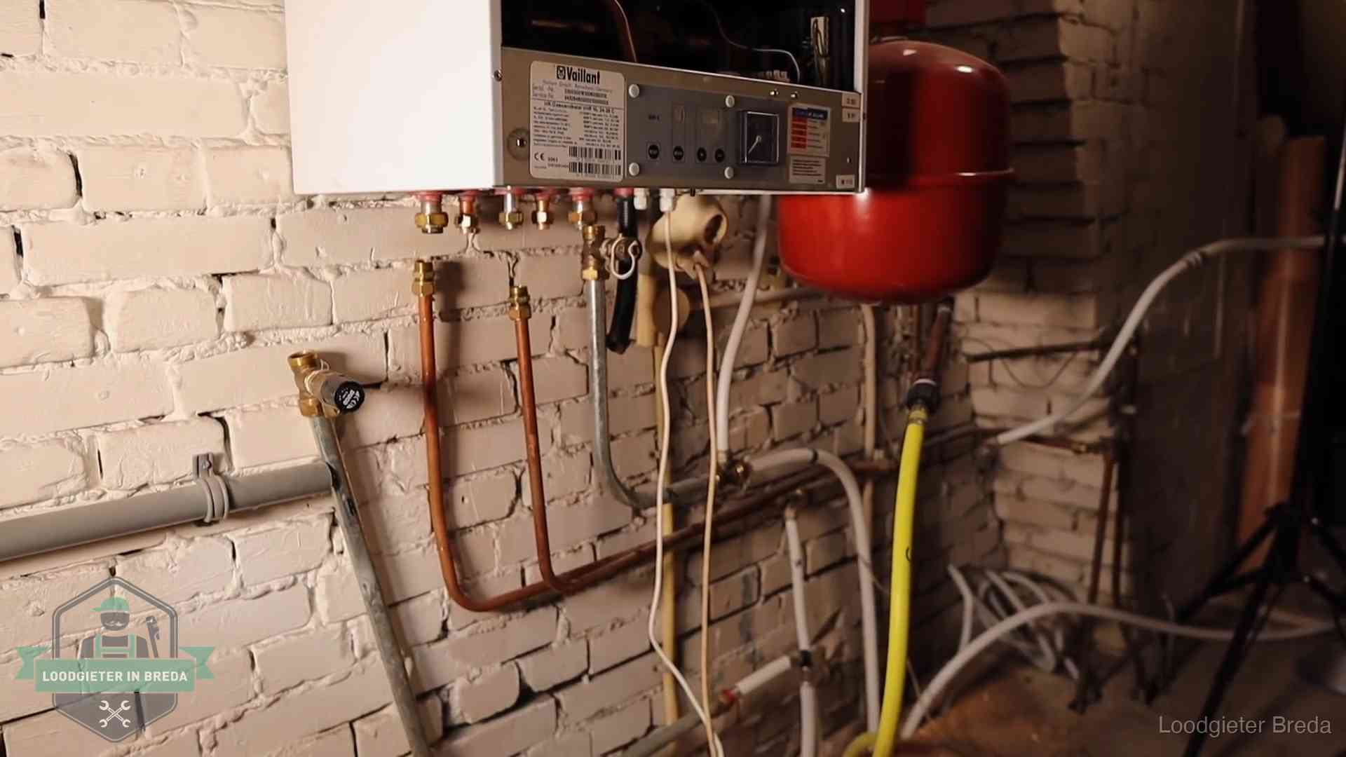 Verouderde cv-ketel met een wirwar van oude leidingen in een woning in Breda