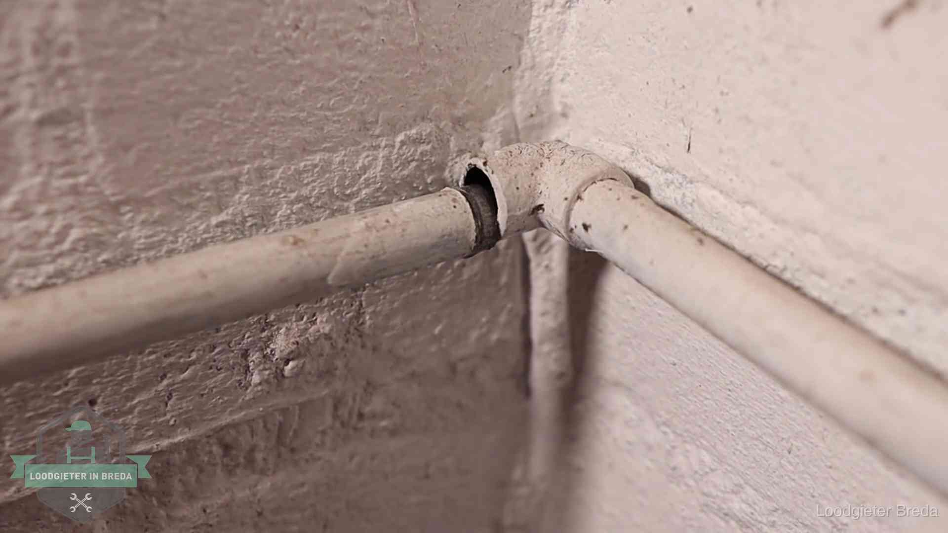 Oude waterleidingen en verborgen lekkage in Breda Oude geverfde waterleiding met een losliggende fitting in een woning in Breda