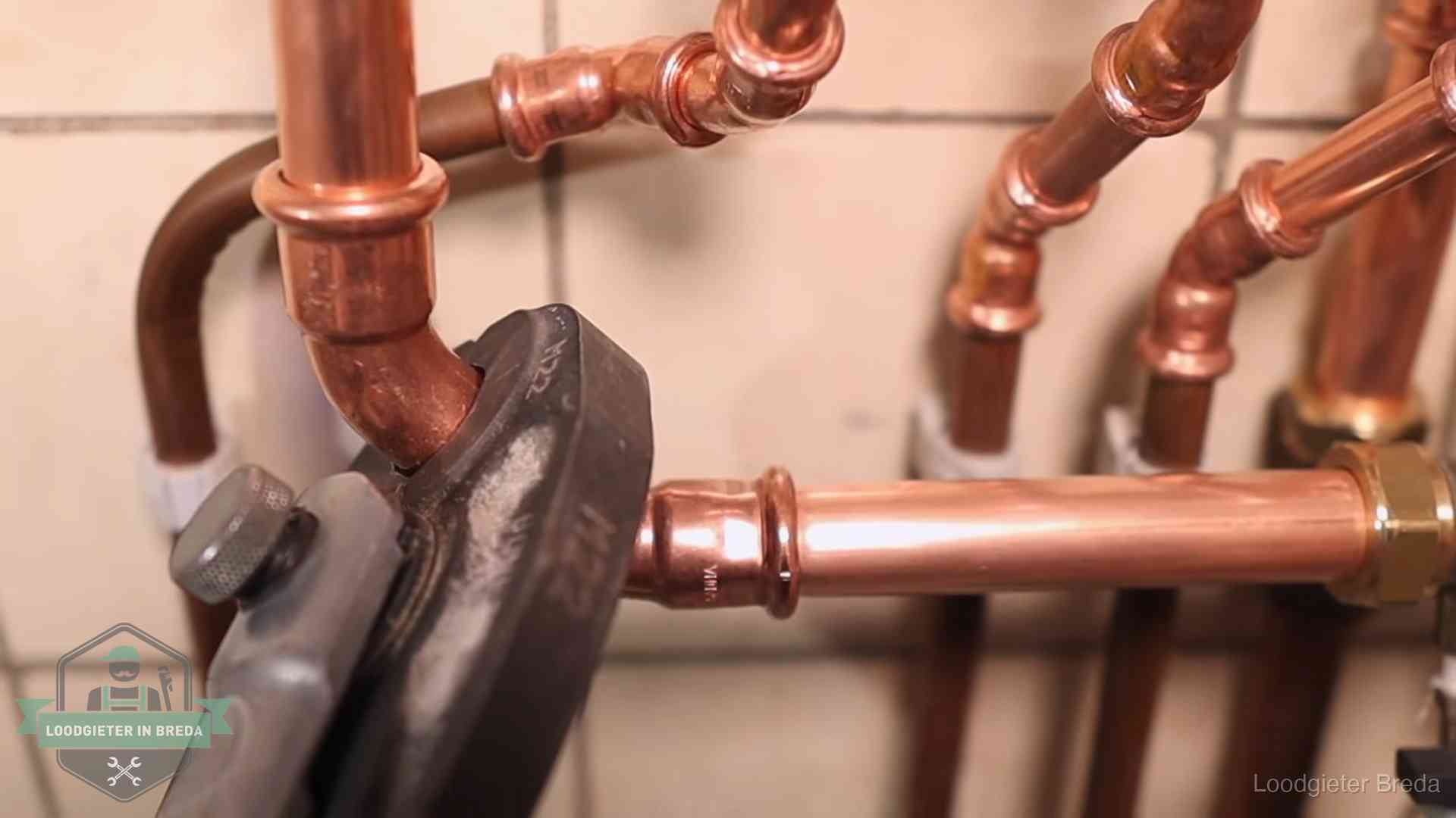 Werkwijze van ons loodgietersbedrijf in Breda Persmachine perst een koperen fitting op nieuw leidingwerk in Breda