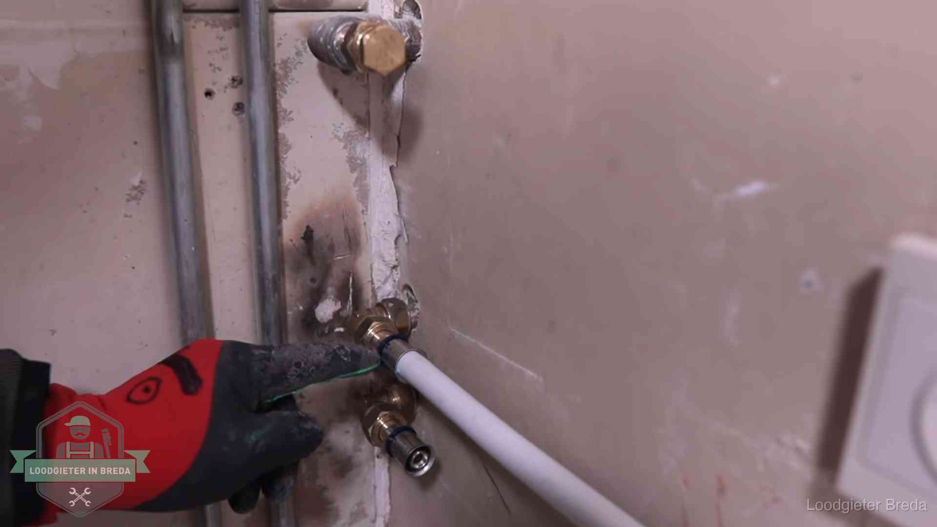 Garantie op loodgieterswerk in Breda Loodgieter wijst de persfitting op nieuwe muuraansluitingen aan in een woning in Breda