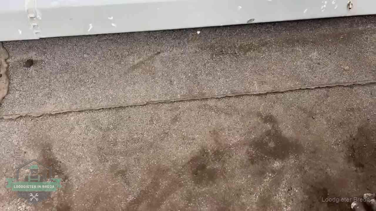 Stormschade en neerslag op daken in Breda Vochtplekken bij de naad van een plat dak na aanhoudende regen in Breda