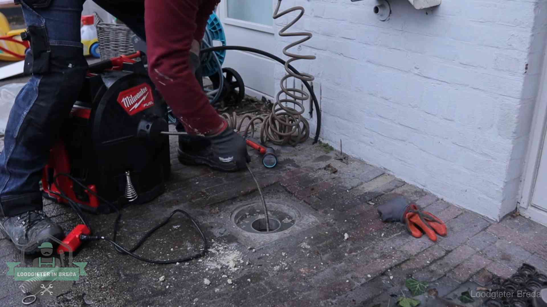 Spiraalmachine bij een ontstoppingsputje in de bestrating in Breda