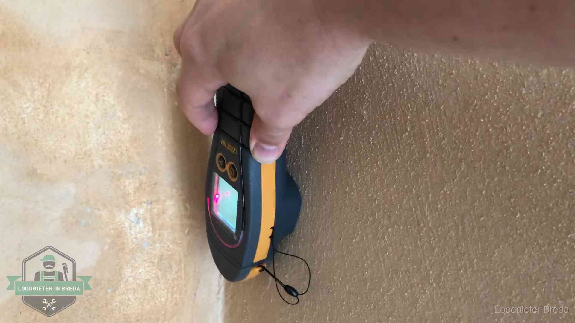 Daklekkage opsporen zonder hakwerk in Breda Vochtmeter tegen een muur met vochtplekken tijdens het opsporen van een daklekkage in Breda