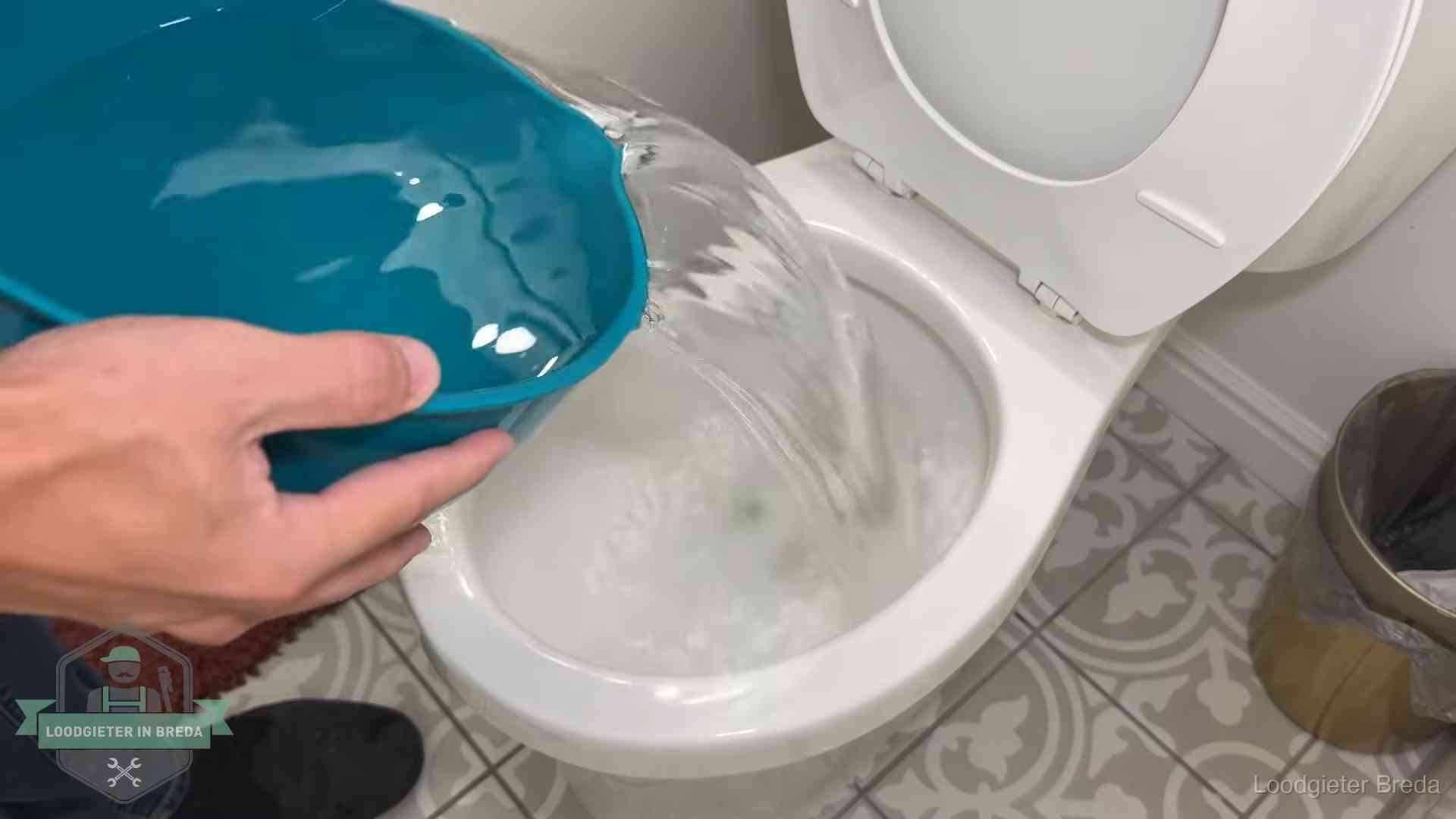 Warm water wordt voorzichtig in de wc-pot gegoten in Breda