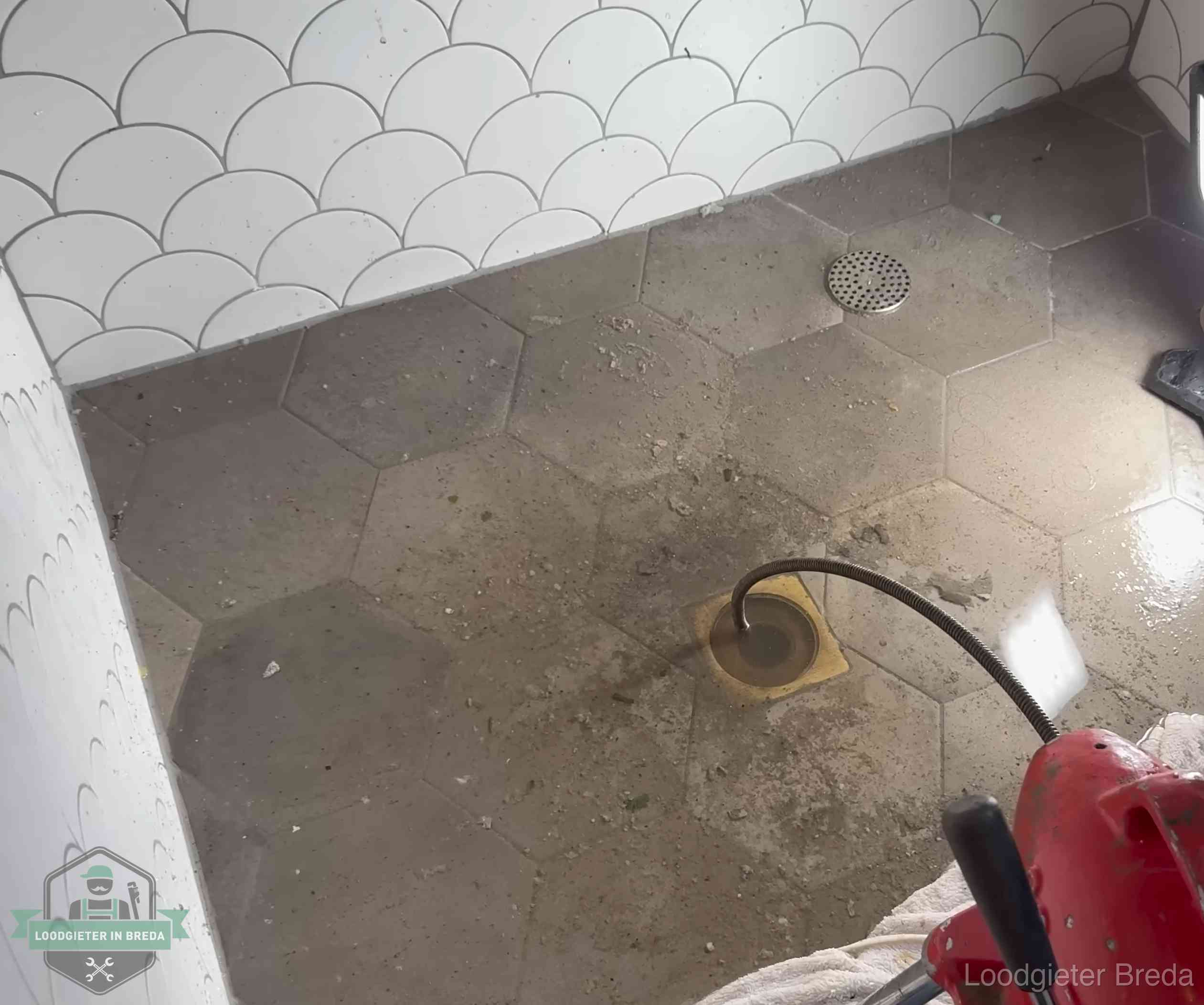 Vloerput met waterslot in een badkamer in Breda, een bron van stank als het waterslot droogstaat