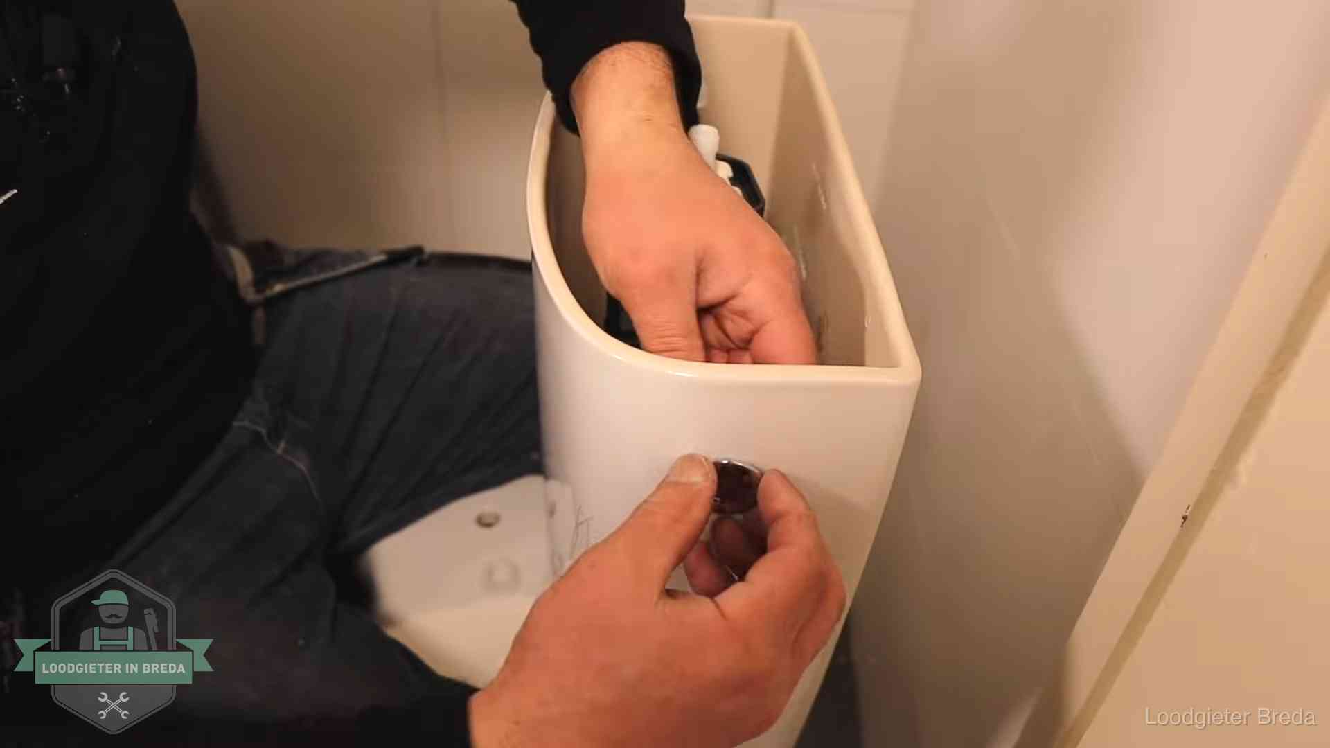 Drukknop van een duoblok-stortbak wordt gemonteerd bij een toilet in Breda