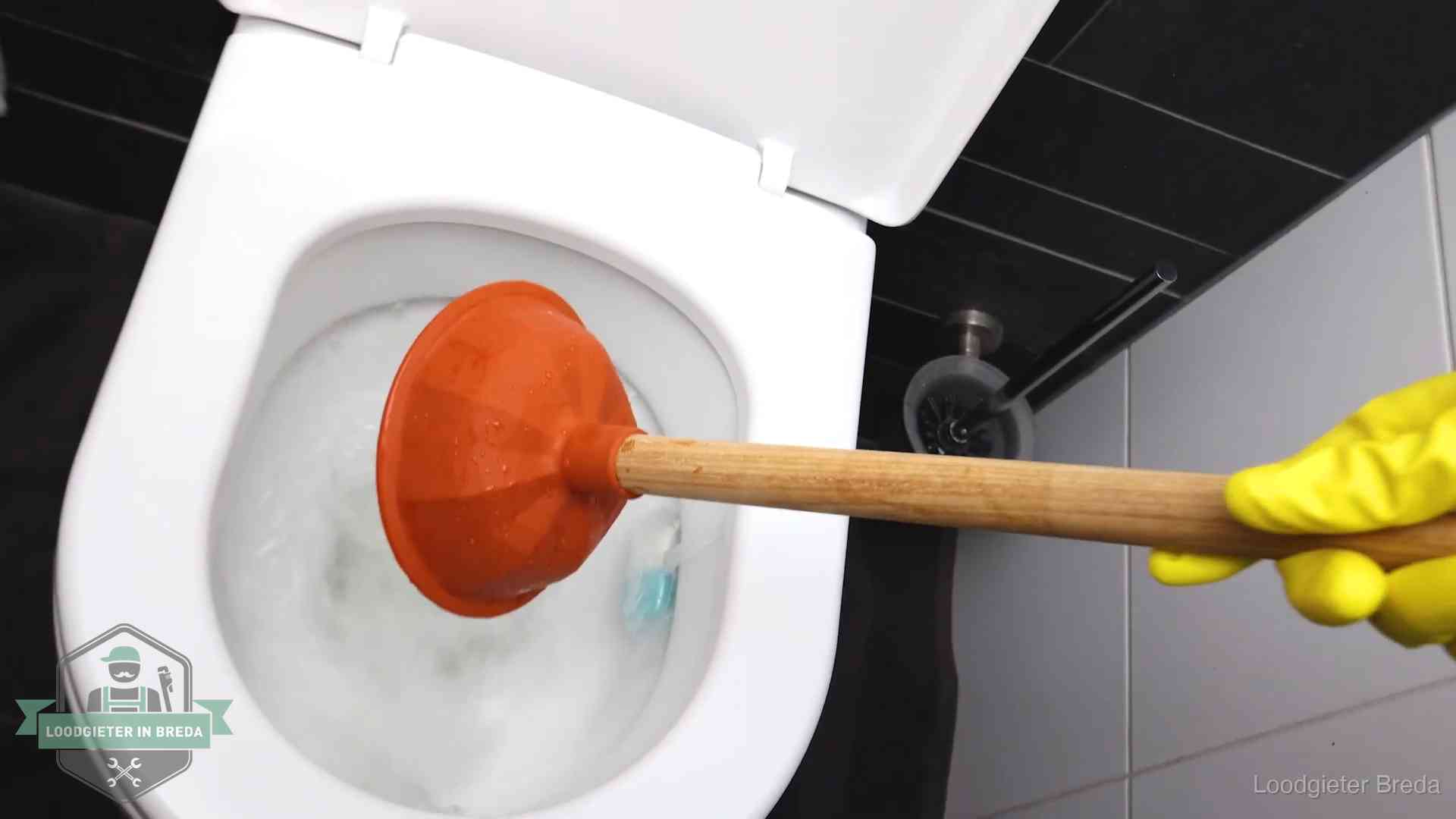 Plopper wordt in de wc-pot gedrukt bij het ontstoppen van een toilet in Breda