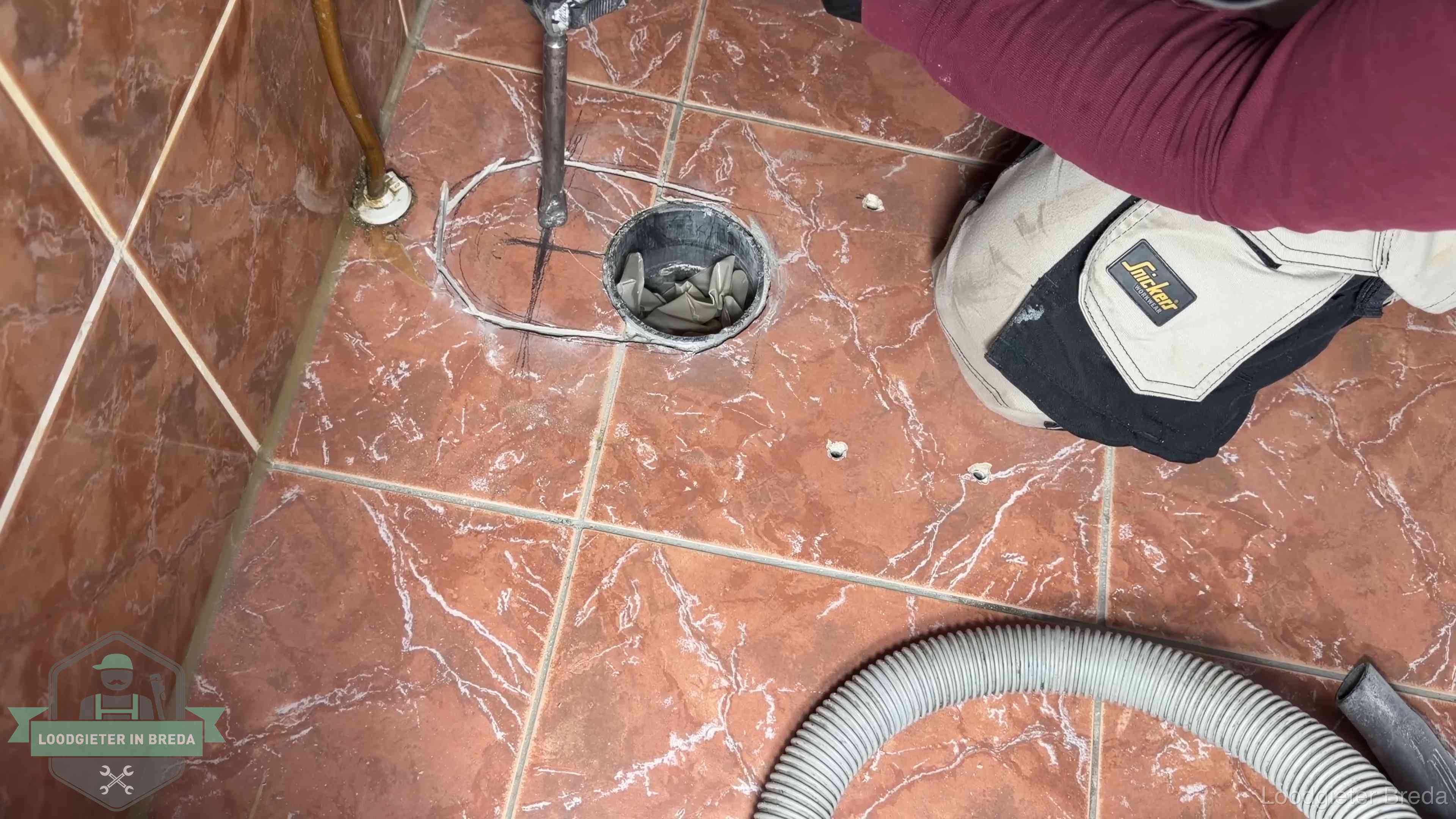 Open rioolaansluiting in de vloer waar de wc-pot is gedemonteerd in Breda
