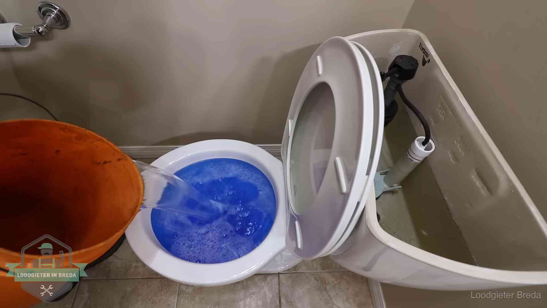 Water bij de wc-pot wordt met een emmer weggewerkt om schade te beperken in Breda
